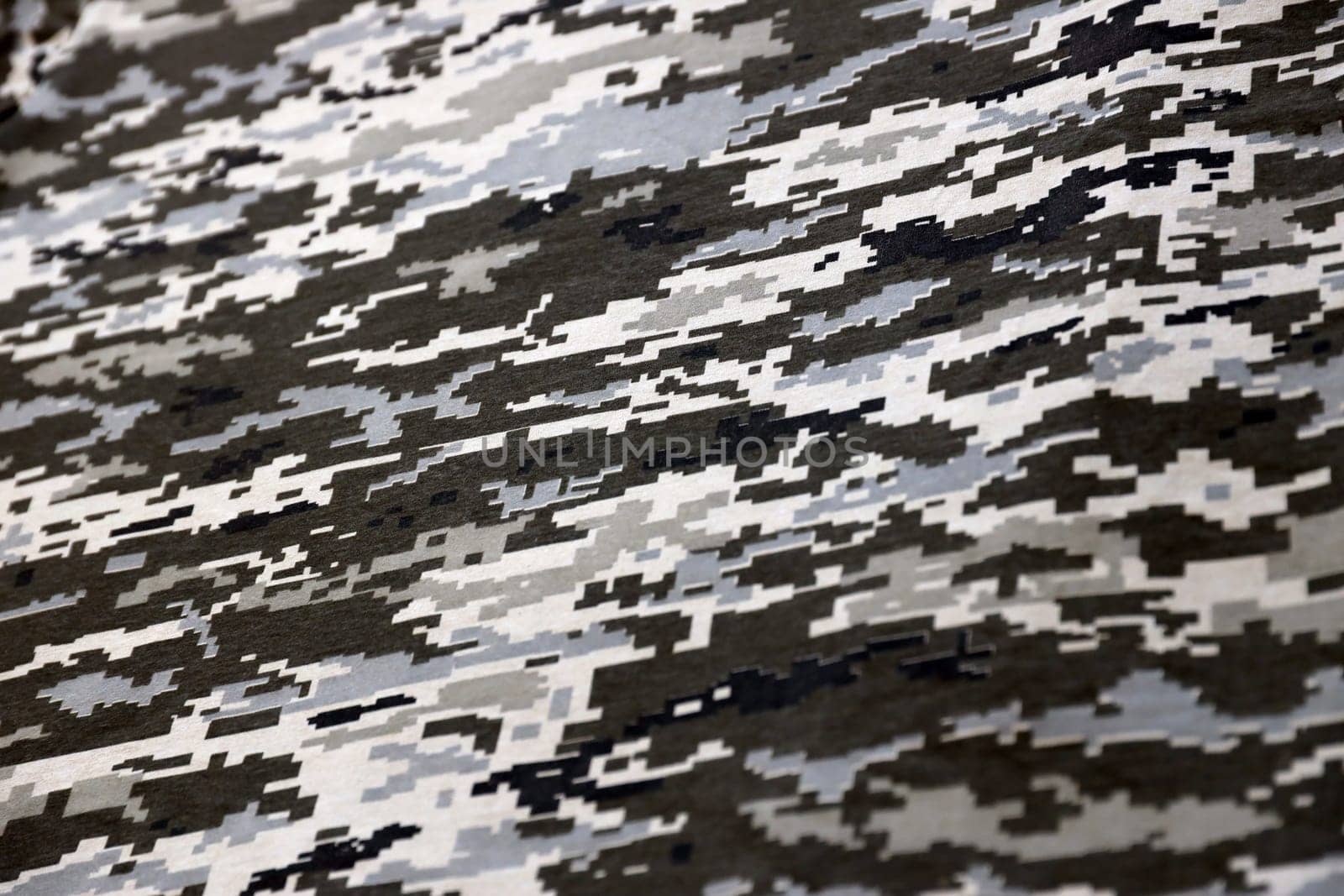 Fabric with texture of Ukrainian military pixeled camouflage. Cloth with camo pattern in grey, brown and green pixel shapes. Official uniform of Ukrainian soldiers close up