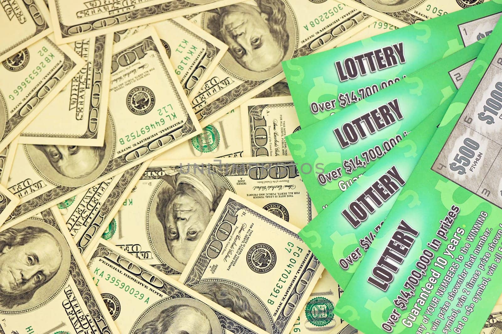 Close up view of green lottery scratch cards and us dollar bills. Many used fake instant lottery tickets with gambling results. Gambling addiction concept.