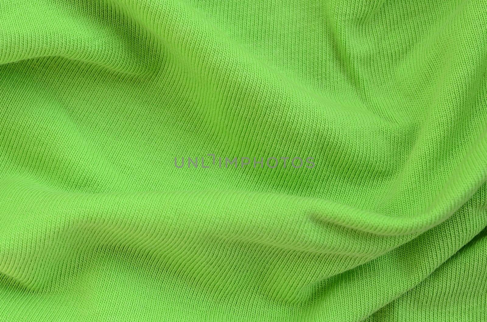 The texture of the fabric is bright green. Material for making shirts and blouses
