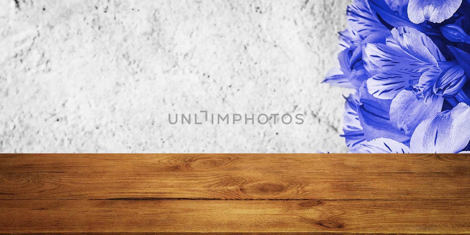 Background flowers on a textured stucco wall and blank wooden planks in the foreground. For product demonstrations, free space, layout, mockup, perspective board, background board.