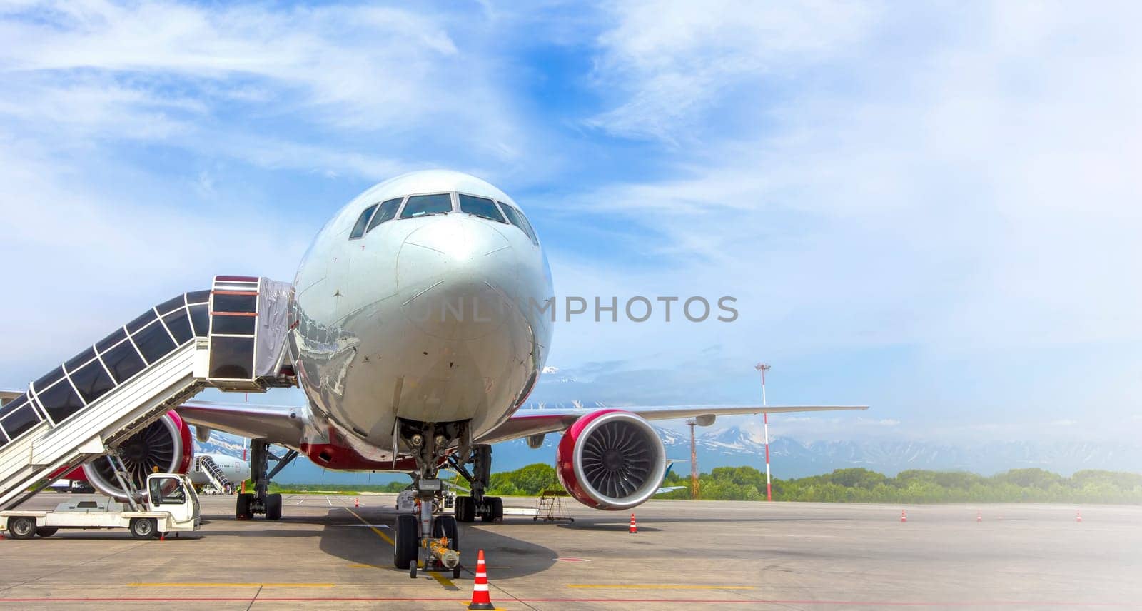 The Airplane with a passenger boarding steps on the airport apron