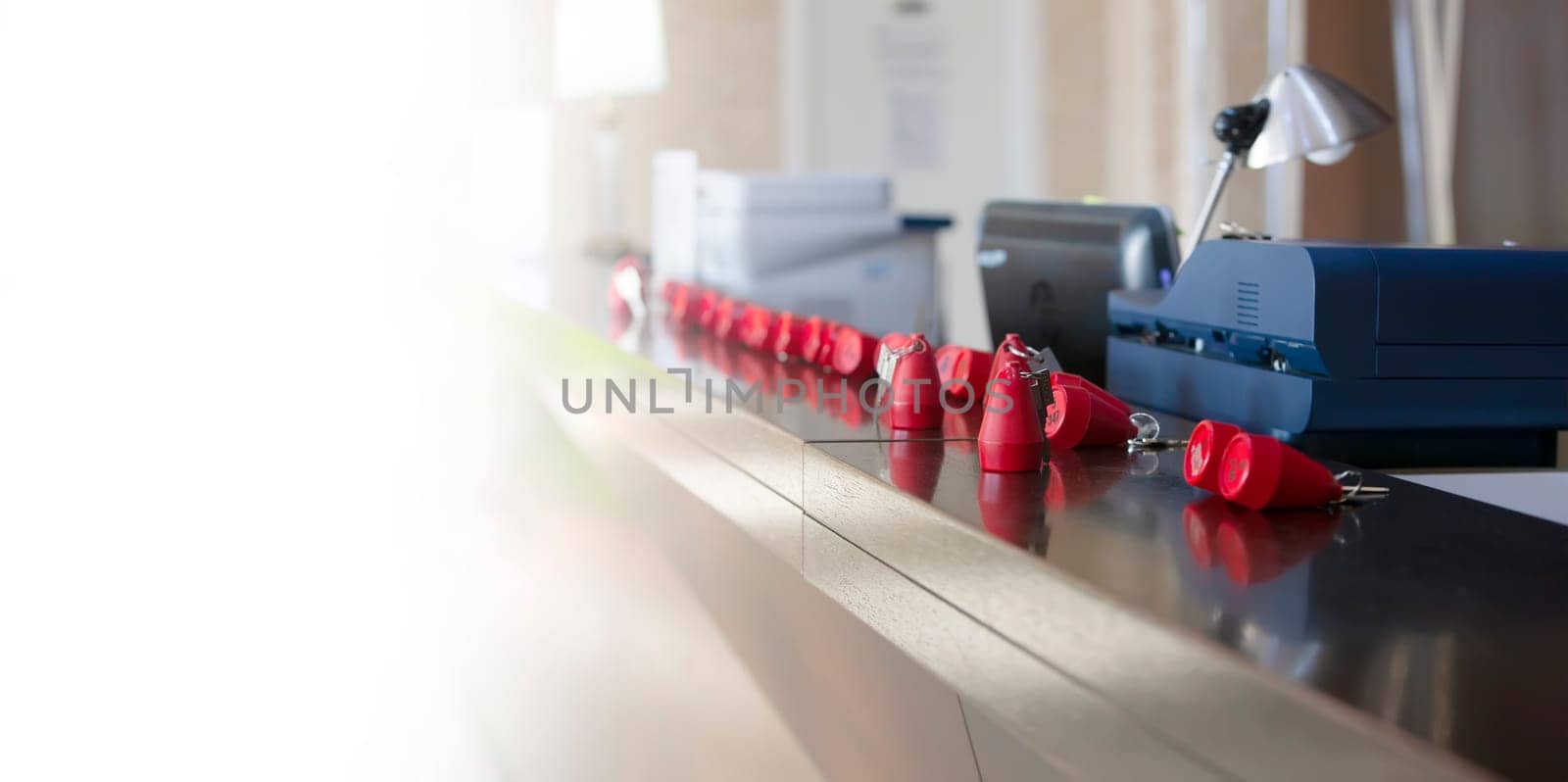 The hotel receptionist with red keys on sun light. Selective focus