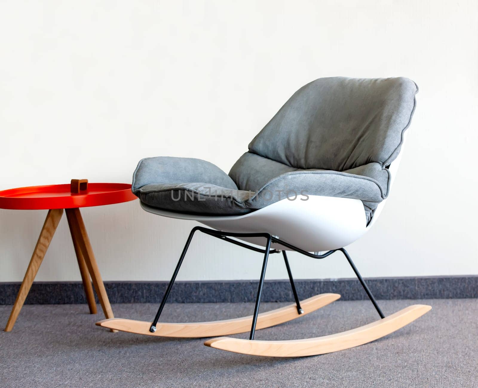 The rocking chair and  table against the wall. Interior inside