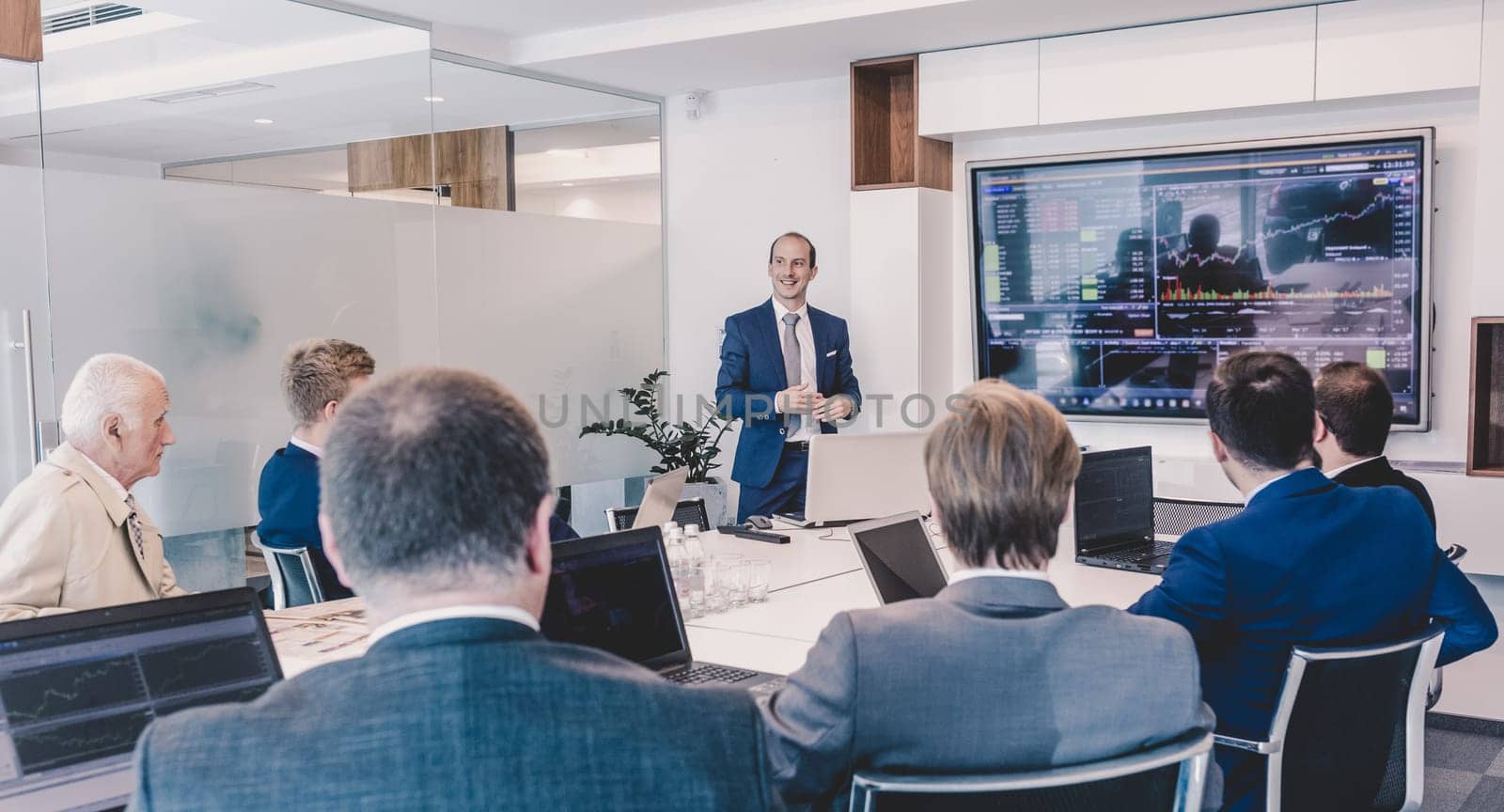 Business man making a presentation at office. Business executive delivering a presentation to his colleagues during meeting or in-house business training, explaining business plans to his employees.