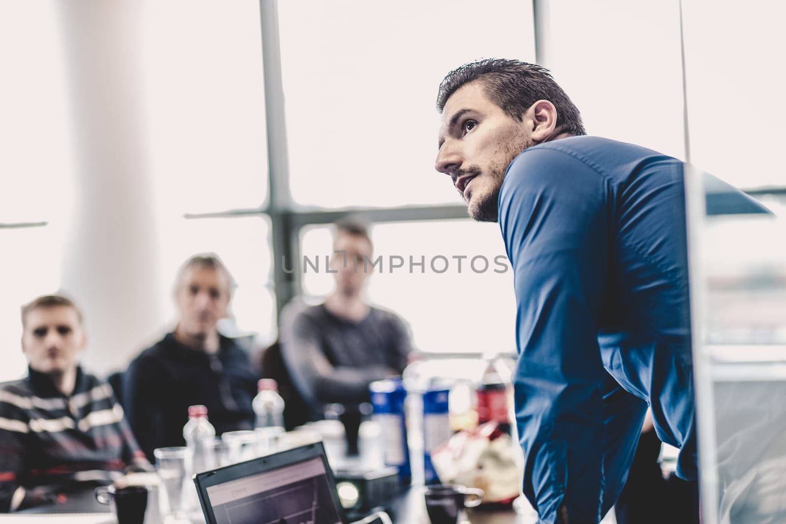 Businessman making a presentation at office. Business executive delivering a presentation to his colleagues during meeting or in-house business training, explaining business plans to his employees.
