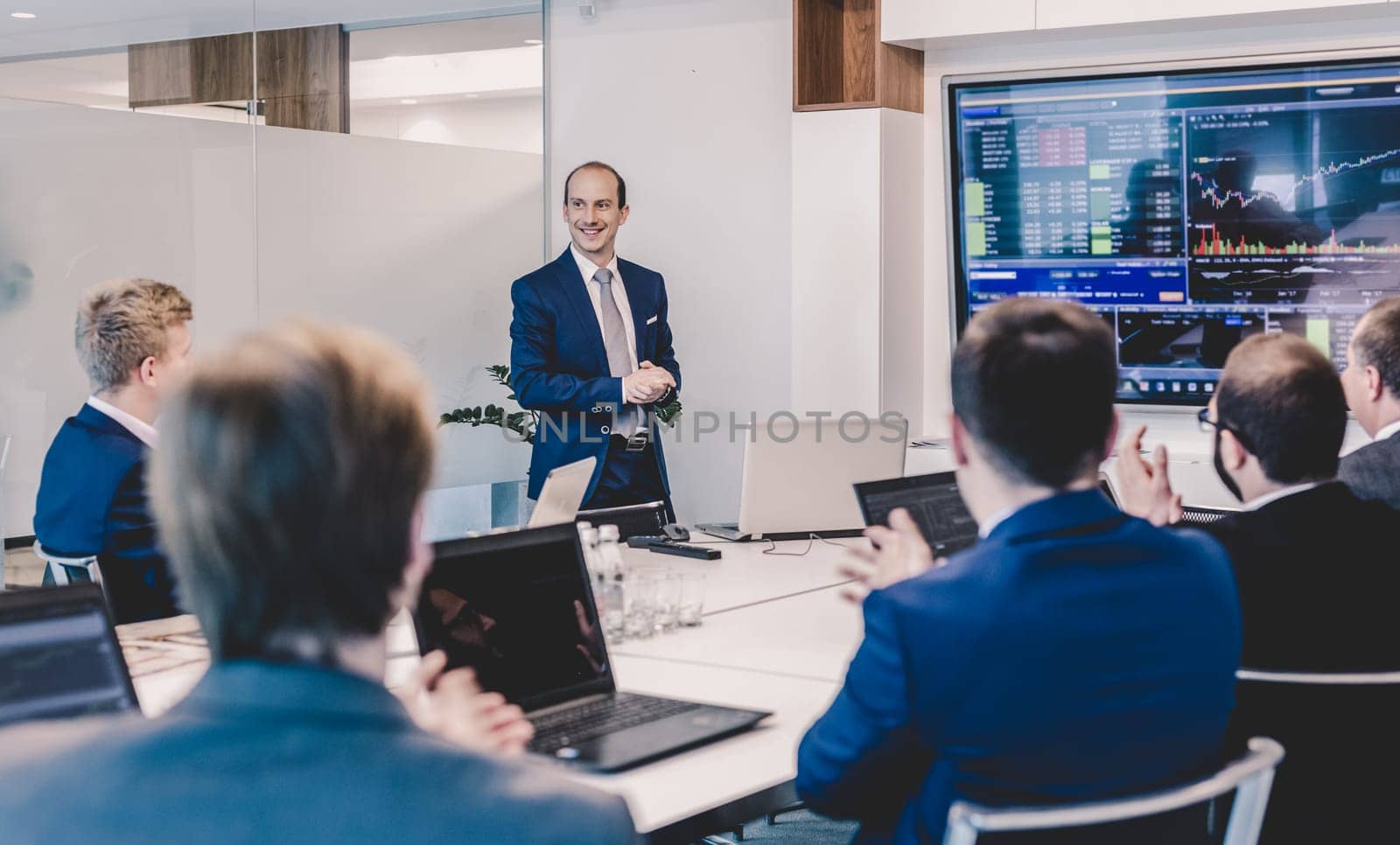 Business man making a presentation at office. Business executive delivering a presentation to his colleagues during meeting or in-house business training, explaining business plans to his employees.