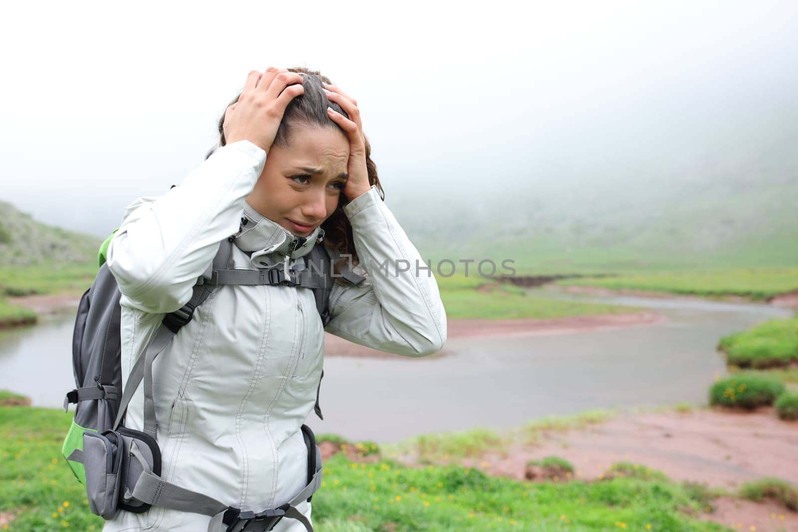 Worried hiker complaining alone walking in the mountain