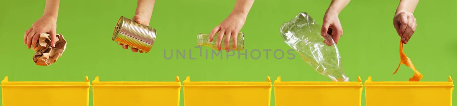 Children's hands throw paper, metal, glass, plastic, organic garbage into different yellow containers on a light green background. Waste sorting. Environment care. Recycling and ecology concept.
