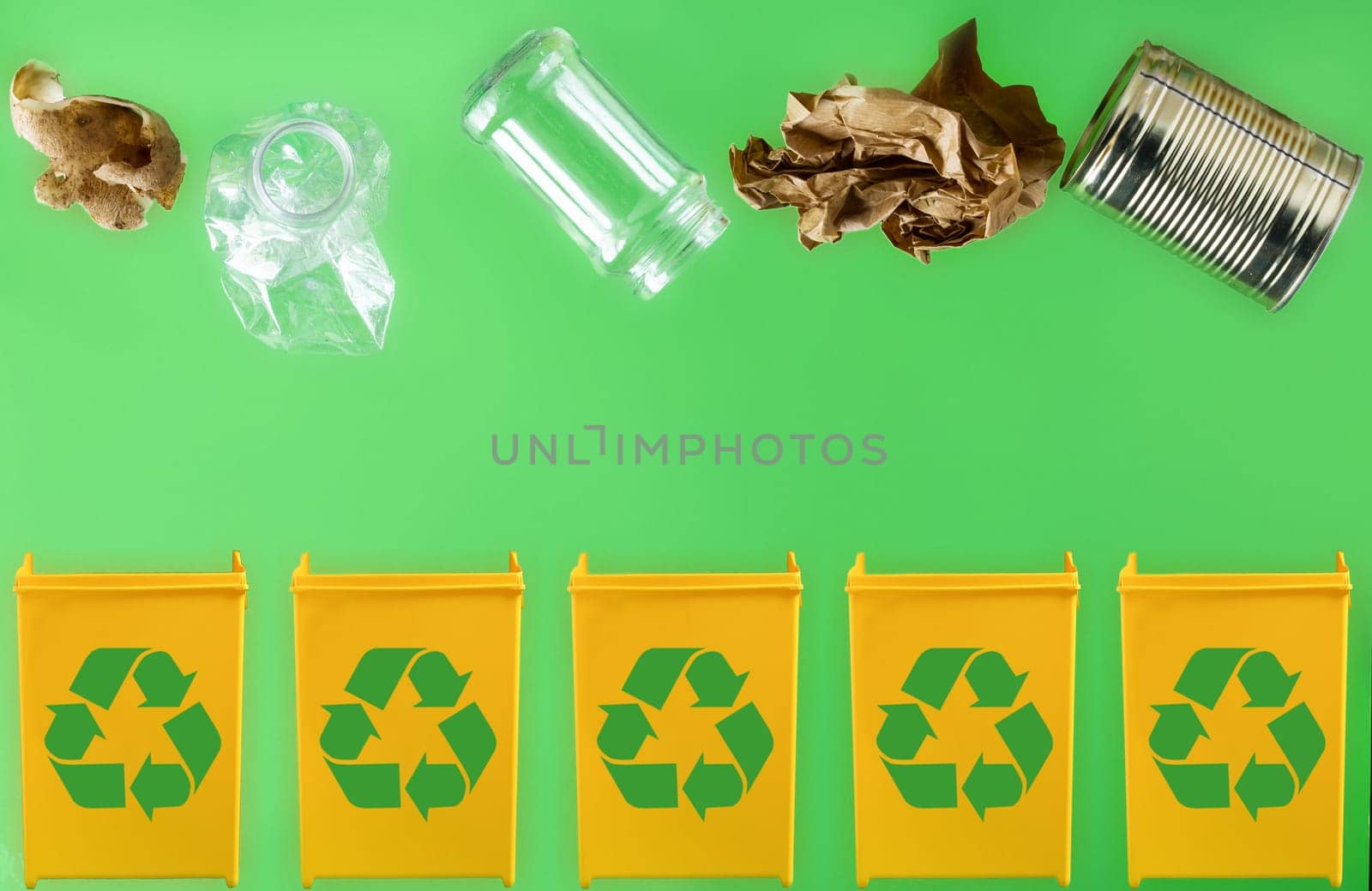 Throwing paper, metal, glass, plastic, organic garbage into different yellow containers on a light green background. Waste separation and recycling concept
