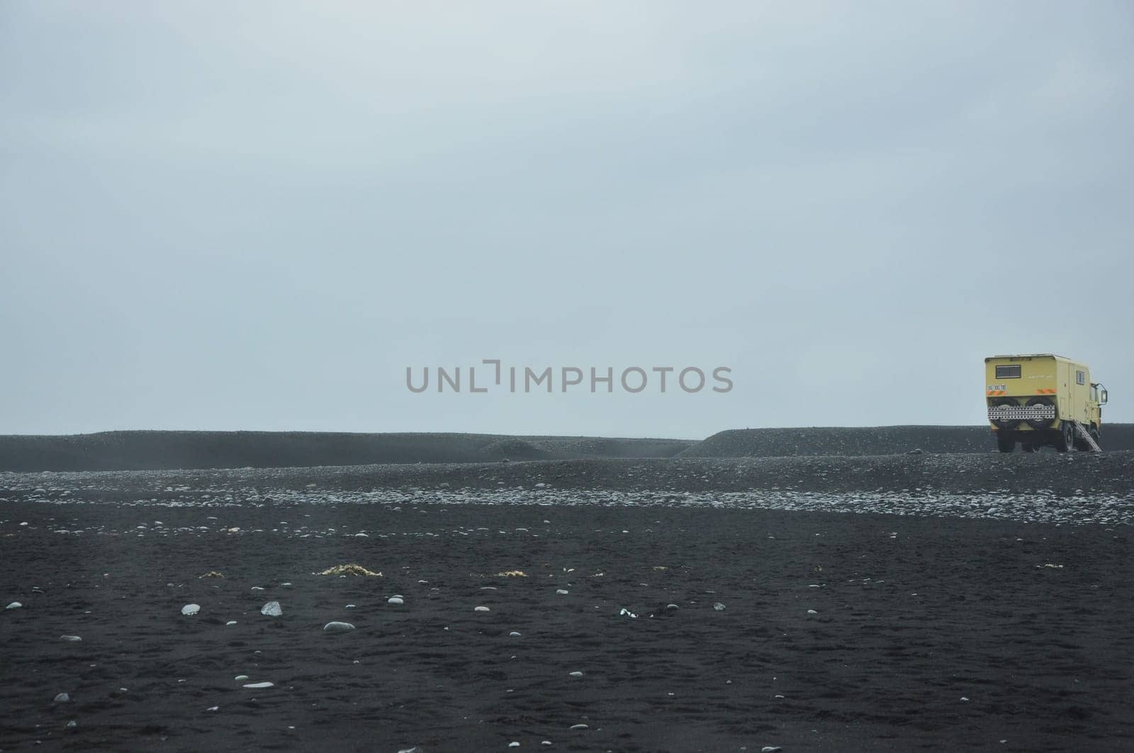 Overlander motorhome captured in a black sand beach