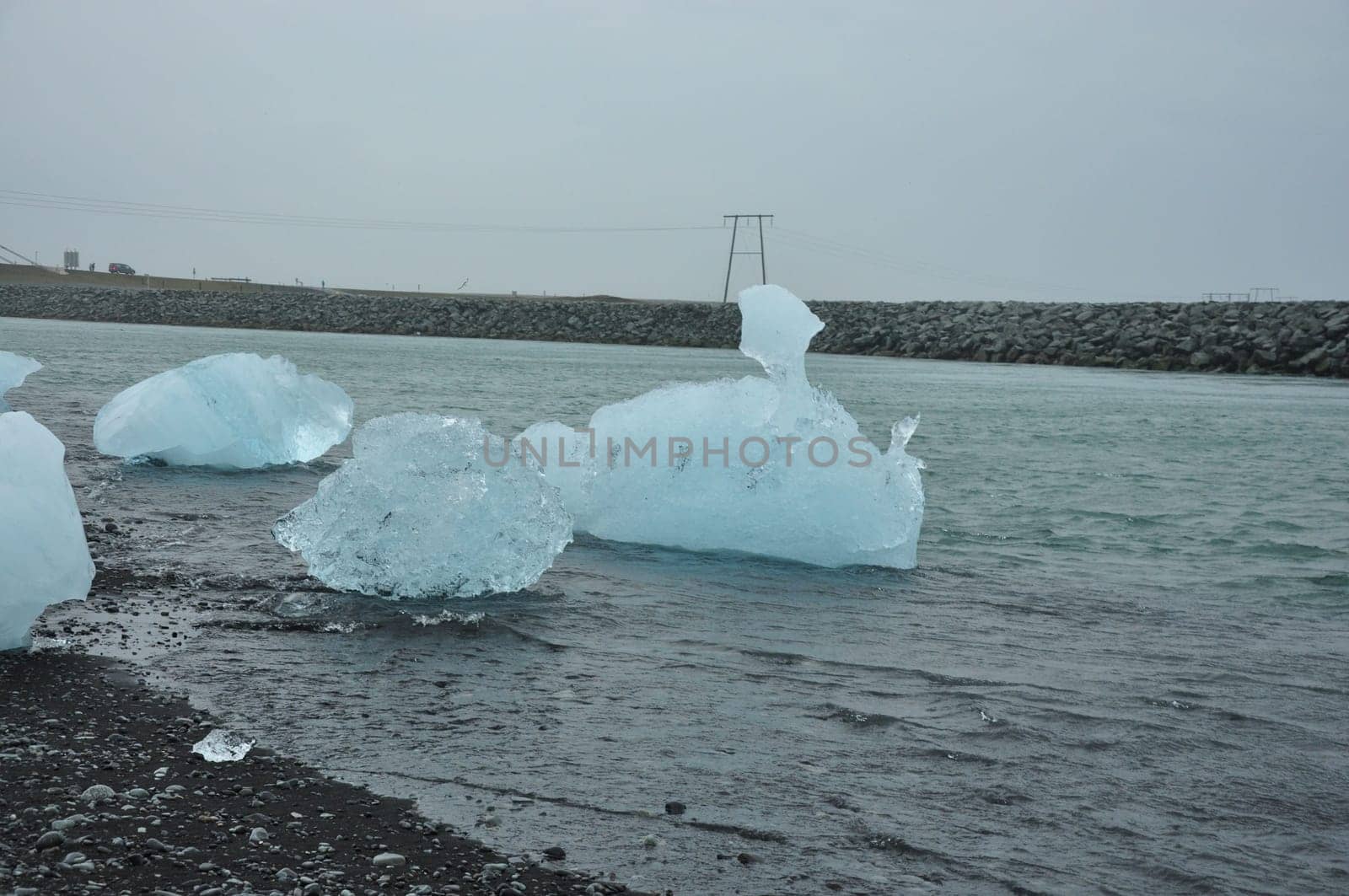 Crystal clear ice chunks at Diamond beach with black sand in Fellsfjara, Jokulsarlon on Iceland