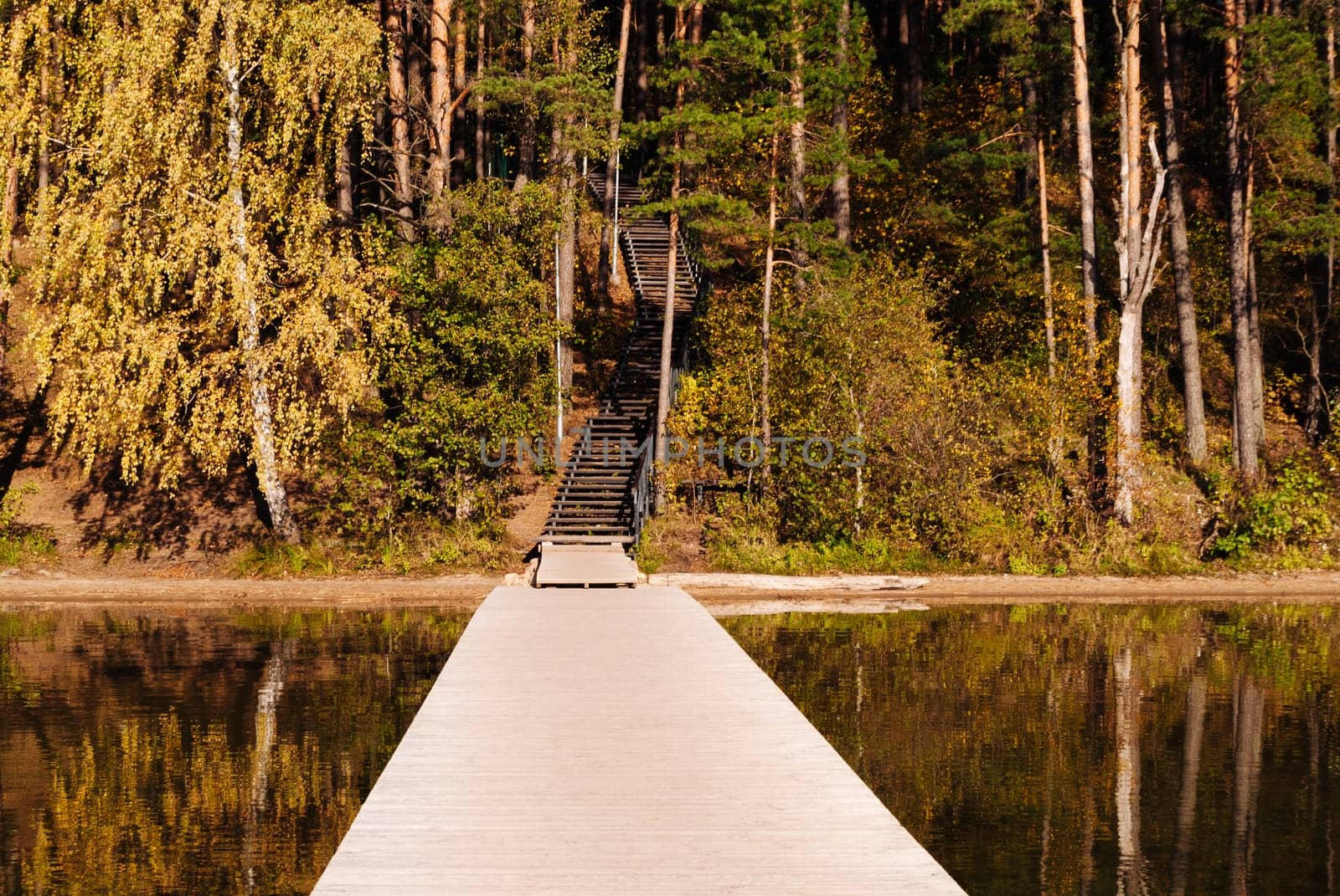 Wooden pier and wooden staircase on the lake Baltieji Lakajai in Labanoras Regional Park in autumn, Picturesque nature of Lithuania.