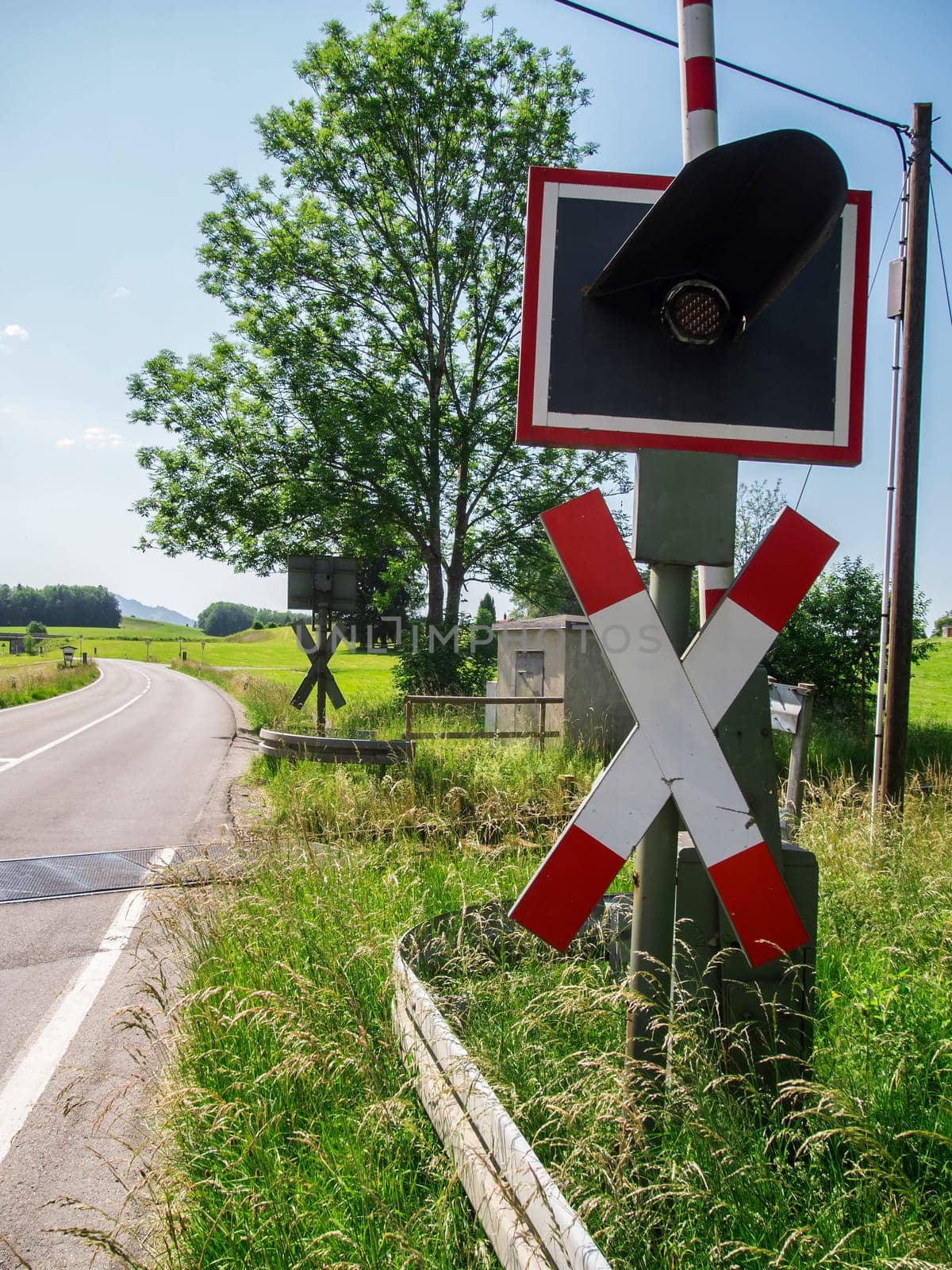 View of a St. Andrew's cross with traffic lights on a country road in Bavaria in summer 2022.