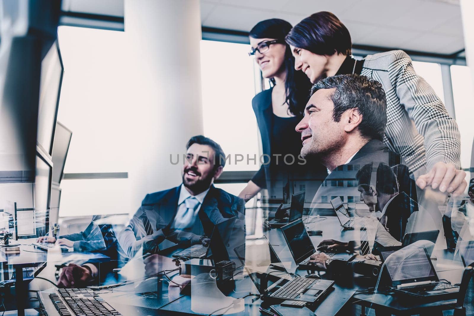 Business team looking at data on multiple computer screens in corporate office. Business people trading online. Business, entrepreneurship and team work concept.
