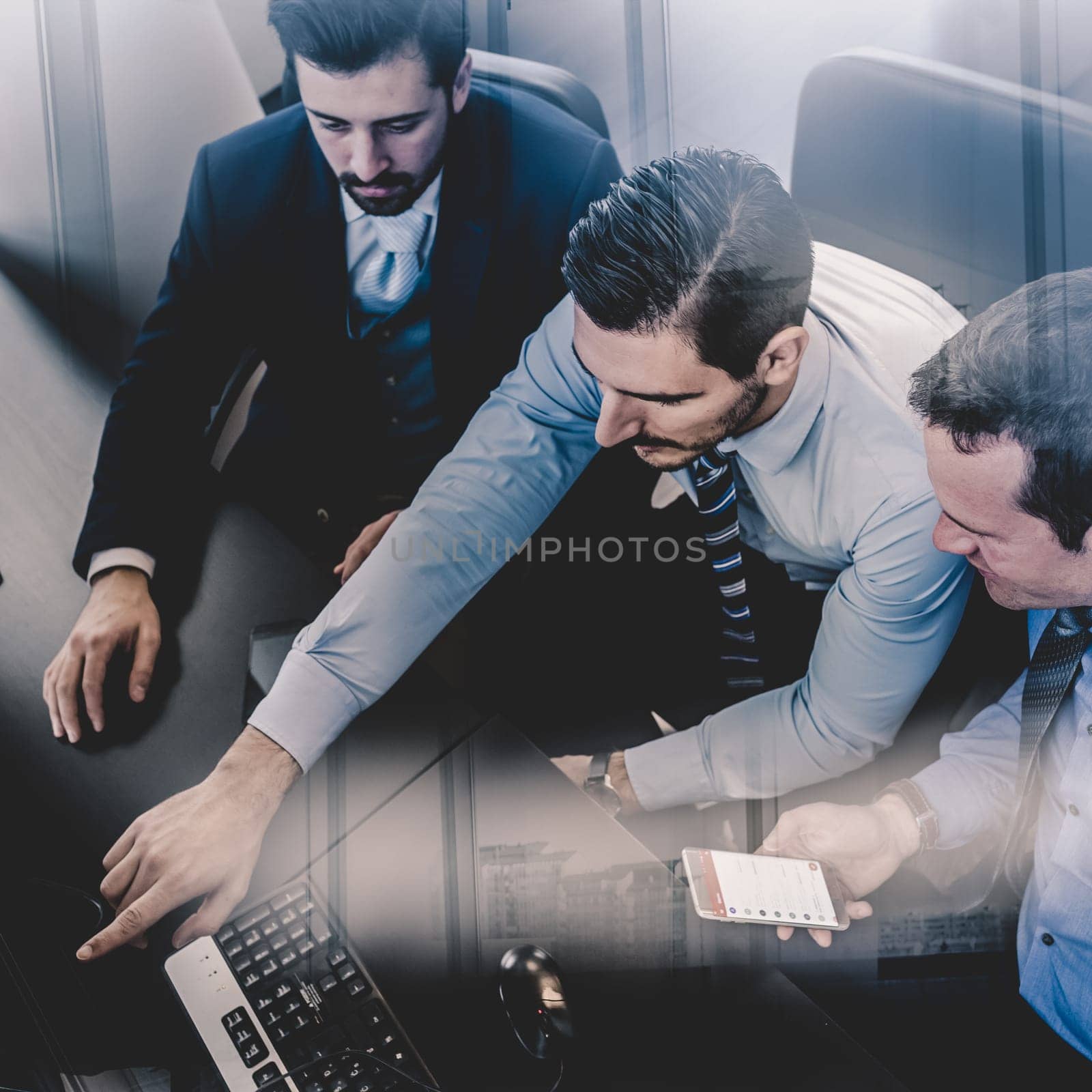 Businessmen trading stocks. Stock traders looking at graphs, indexes and numbers on multiple computer screens. Colleagues in discussion in traders office. Business success concept.