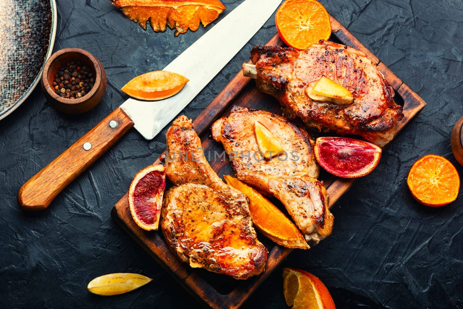 Roasted delicious meat in orange sauce. Pork on the bone