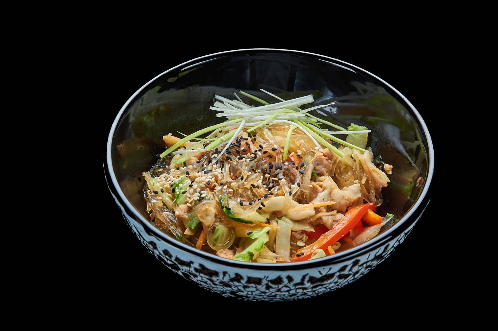 Harusame noodles with seafood in a deep bowl on a black isolated background. High quality photo