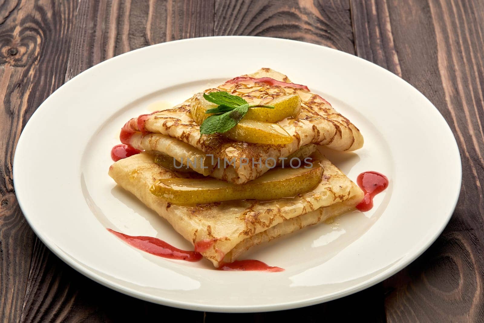 delicious juicy pancakes drizzled with sauce are served on a white plate. High quality photo