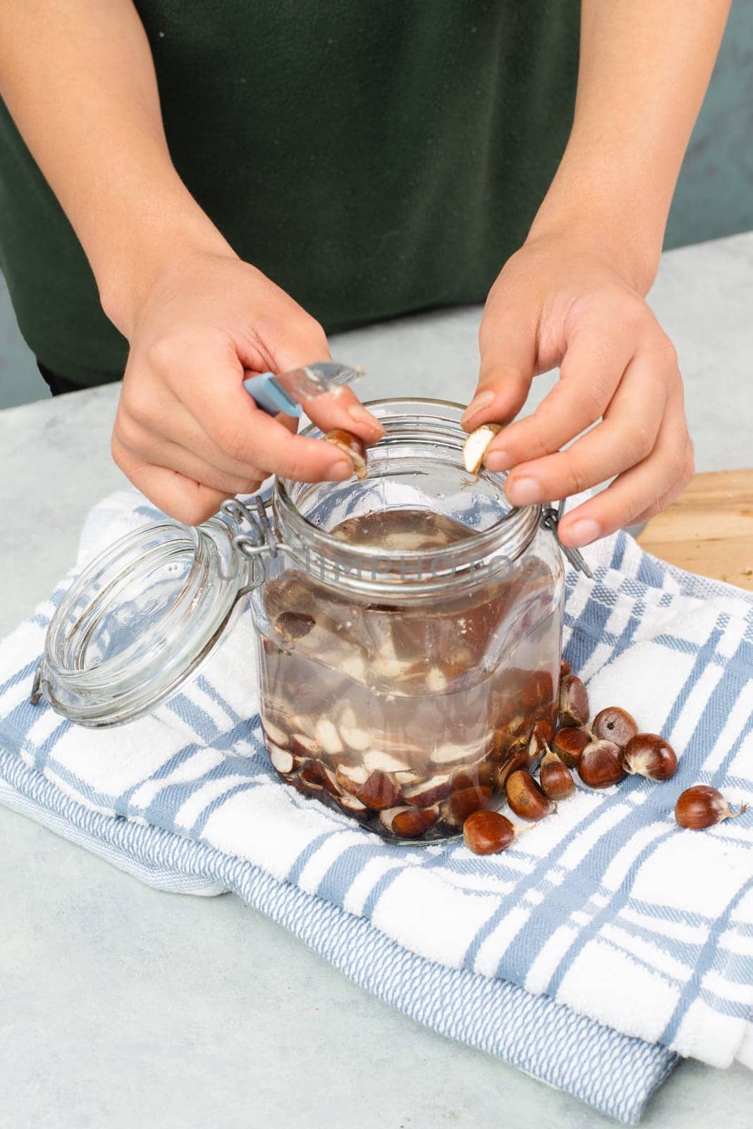 Preparing chestnut liquid soap, cutting buckeye and putting it into a jar with water, alternative homemade detergent for washing clothes