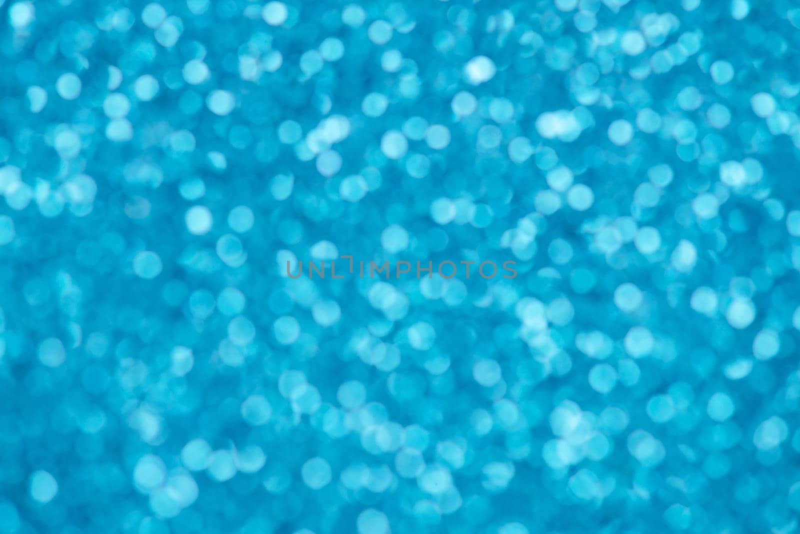 Blue bokeh background for christmas, defocused round lights and sunbeams, flare overlay