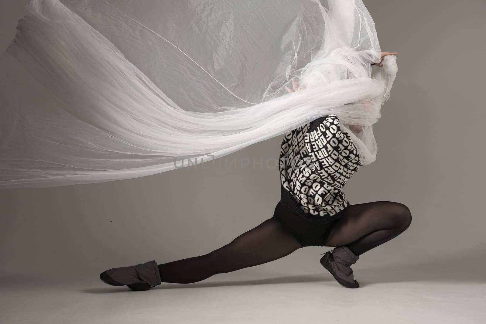 Ballerina Dancing with Silk Fabric, Modern Ballet Dancer with Waving white fabric, Gray Background. With text on sweater DREAMS OF.