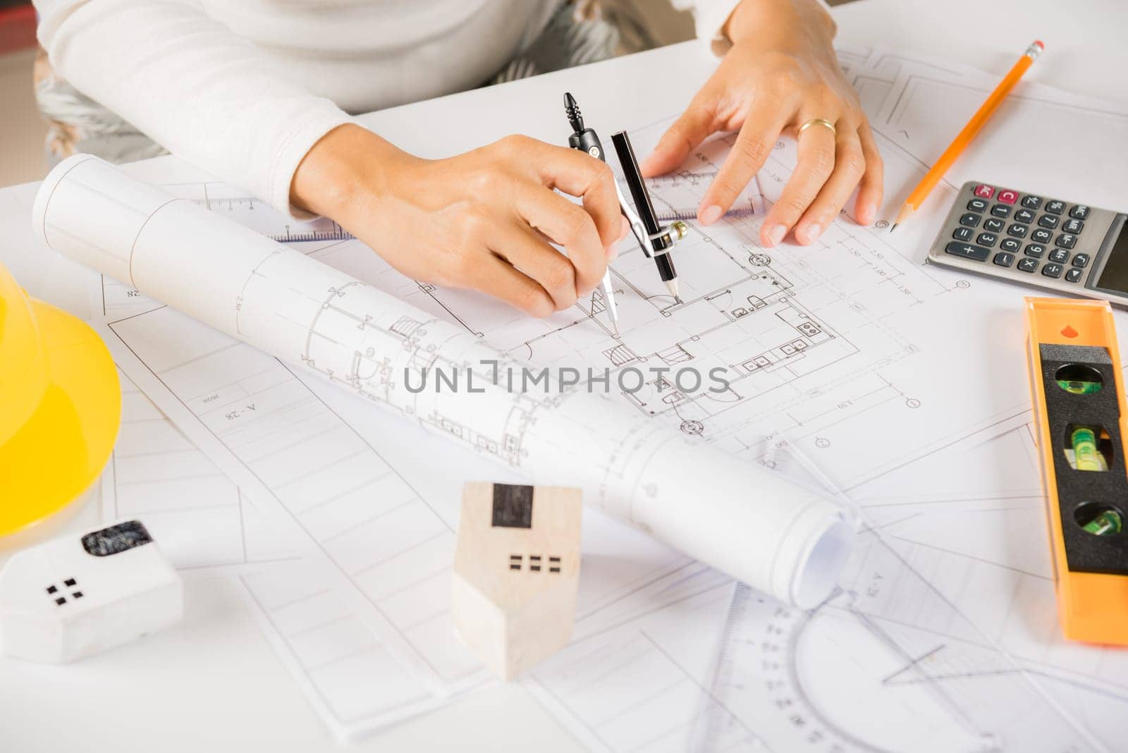 Architectural project workplace. Architect drawing with divider compass on house plan blueprint paper for repair tools on table desk at architecture office, Engineer sketching construction project