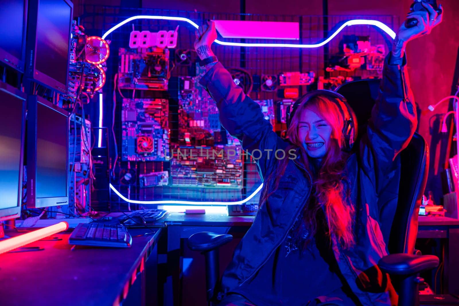 Winning. Happy Gamer young plays online video games computer she raises hands to wins tournament, young woman in gaming headphones playing video game online at home feel excited, E-Sport concept