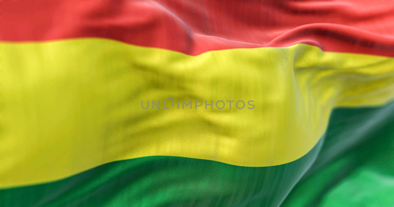 Close-up view of the Bolivia national flag waving in the wind. The Plurinational State of Bolivia is a State of South America. Fabric textured background. Selective focus