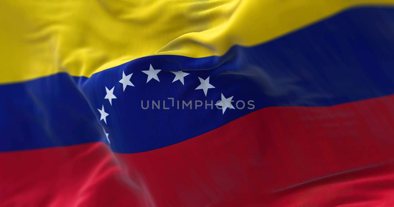 Close-up view of Venezuela national flag waving in the wind. The Bolivarian Republic of Venezuela is a state located in North South America. Fabric textured background. Selective focus