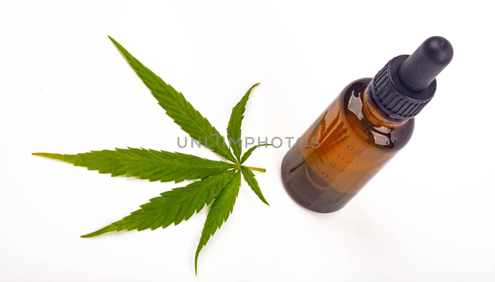 Cannabis oil hemp oil with fresh cannabis leaf on bright background