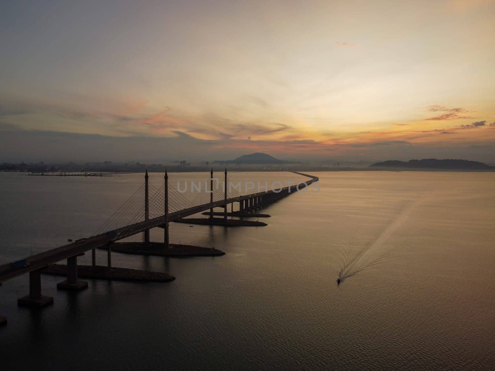 Aerial view morning sunrise of Penang Bridge. Fisherman boat sail at sea