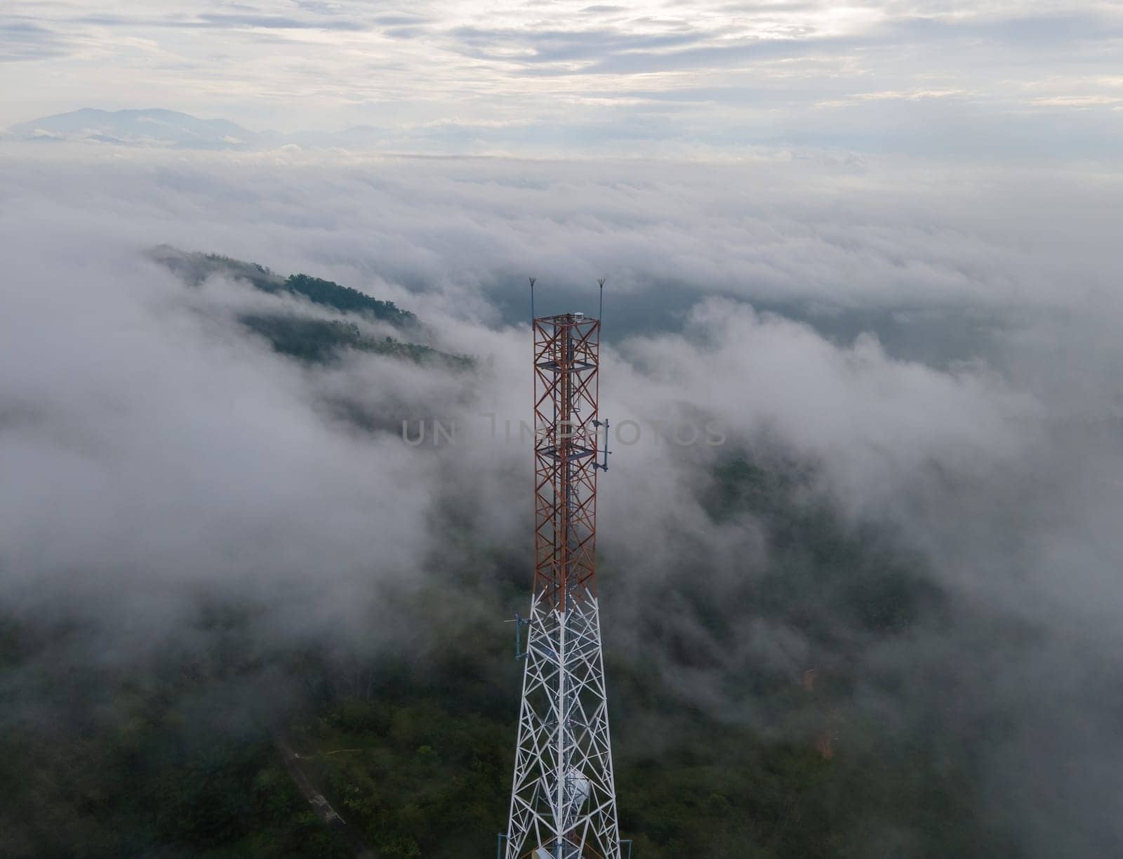 Aerial view telecommunication tower in misty forest