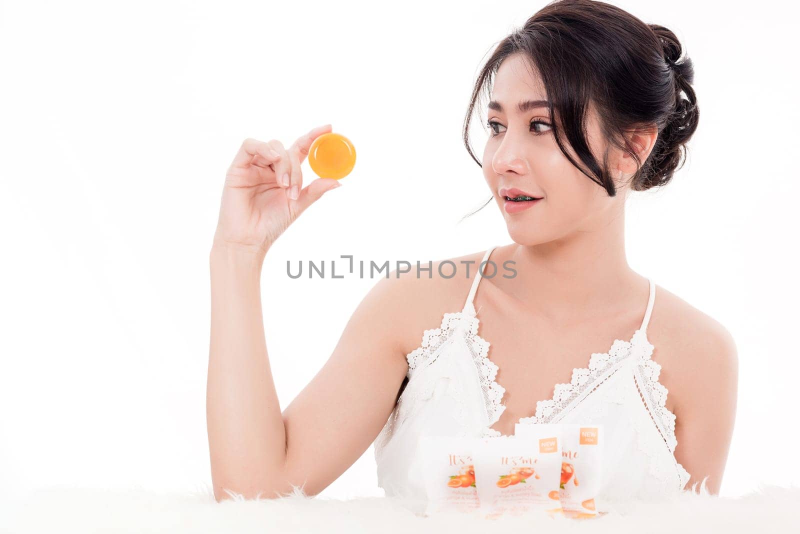 Asian young beautiful woman smiling she's holding orange handcrafted organic soap skin care near face for present product isolated on over white background, Beauty Zero waste concept