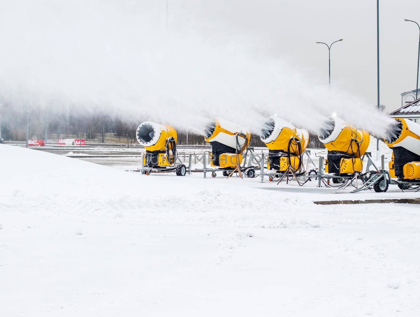 Shot of the industrial machinery so called snow gun or snow cannon that produces artificial snow in action.