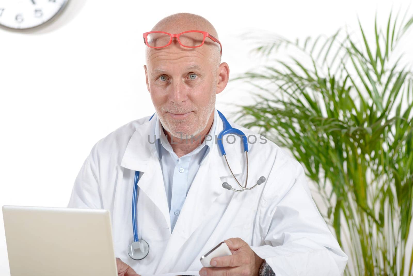 a doctor in his office with red glasses