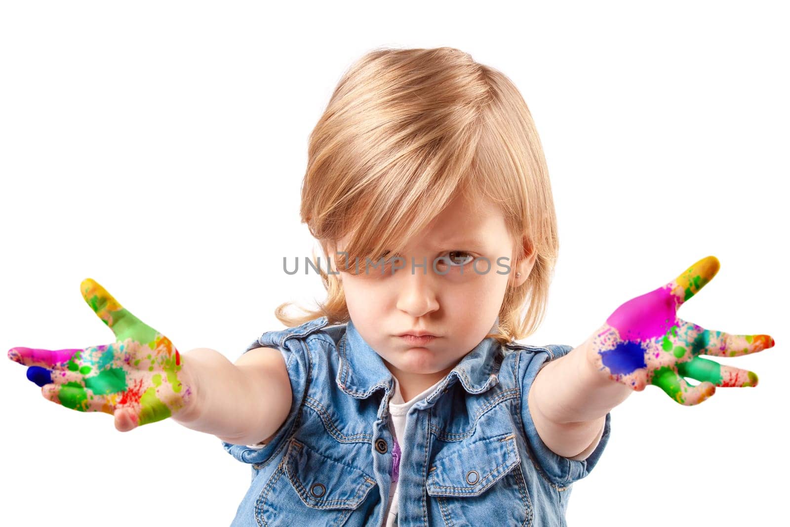 Unhappy little girl with her ??hands stained with colors