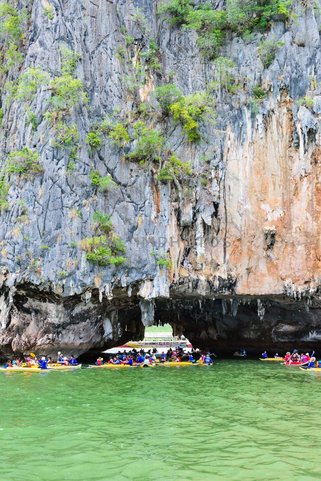 PHANG NGA, THAILAND - APRIL 27 2015: Tourists are happy with the canoeing near island on the sea surface at Tham Lod cave in Ao Phang Nga Bay National Park, APRIL 27 2015 in Thailand