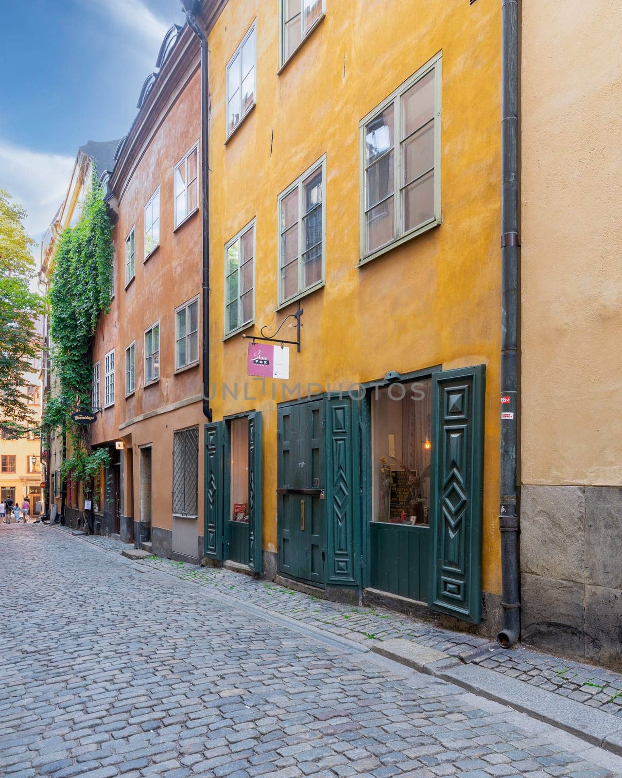 Narrow alley in Gamla stan, the old town of Stockholm, Sweden, with old style orange colored houses and cobblestone street, Stockholm, Sweden