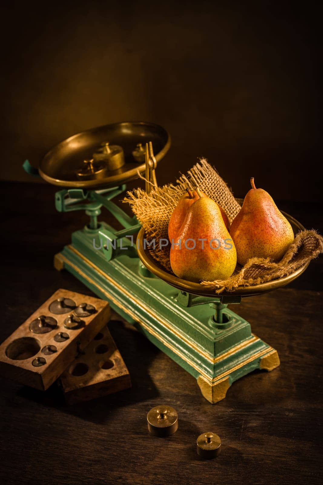 Organic pears on old vintage scales with brass weights on wooden background