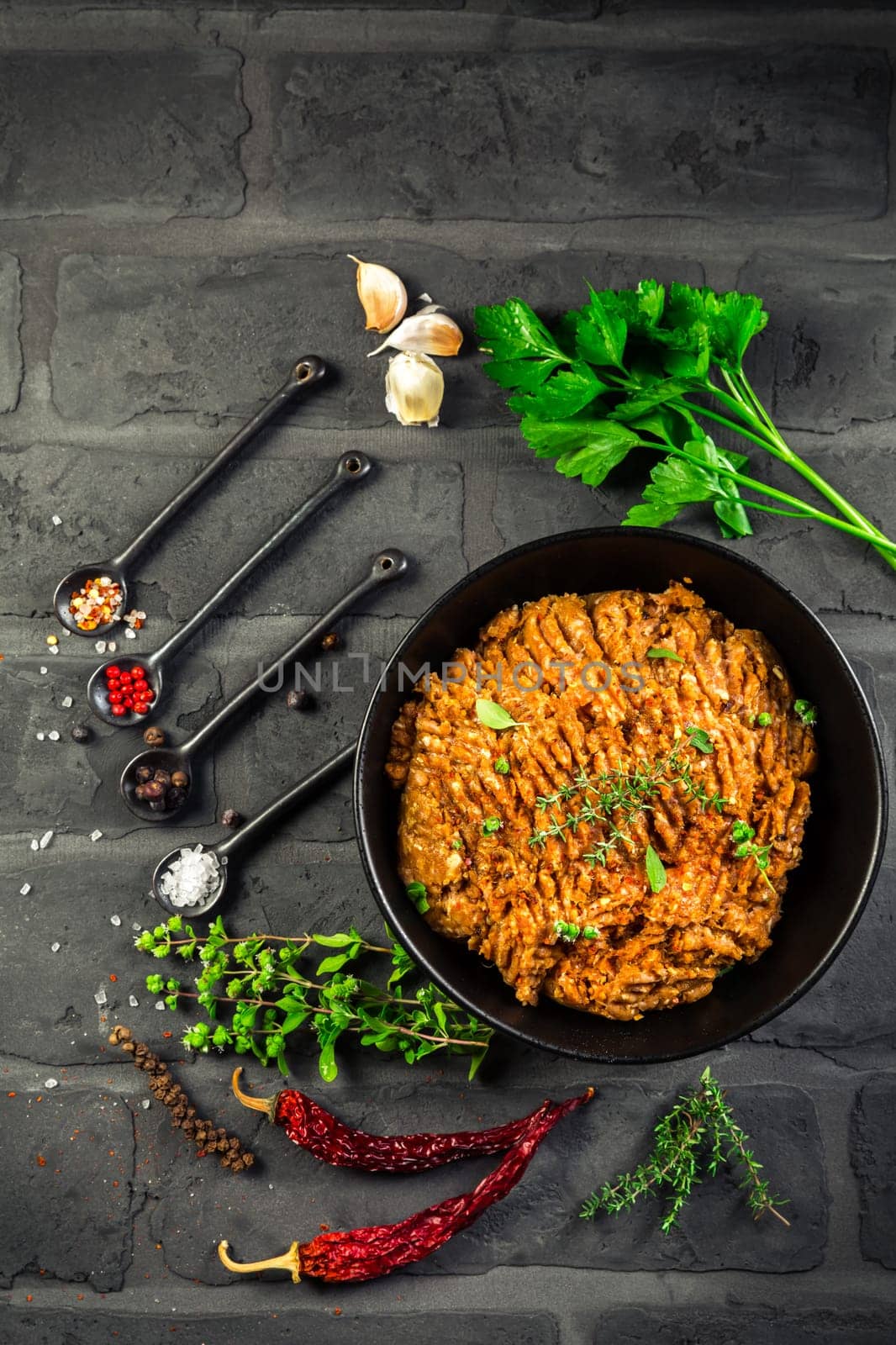 Mince. Marinated Ground meat with ingredients for cooking on black background. Top view