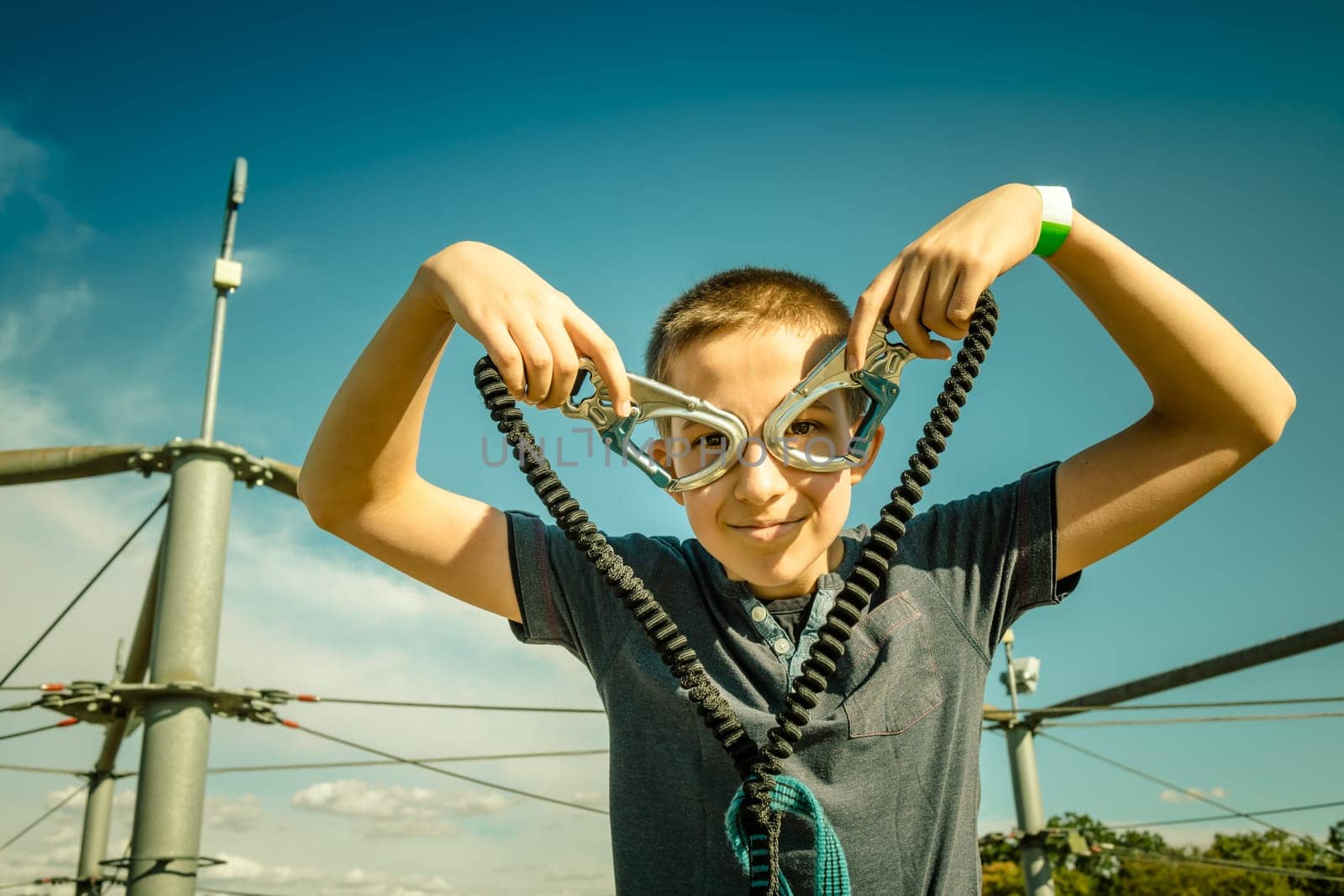 Zipline equipment for safety,  adventure in  high ropes course.  Happy boy reached highest platform.