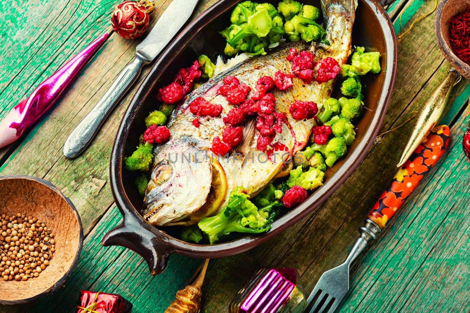 Tasty baked whole fish in fruit marinade on old wooden table