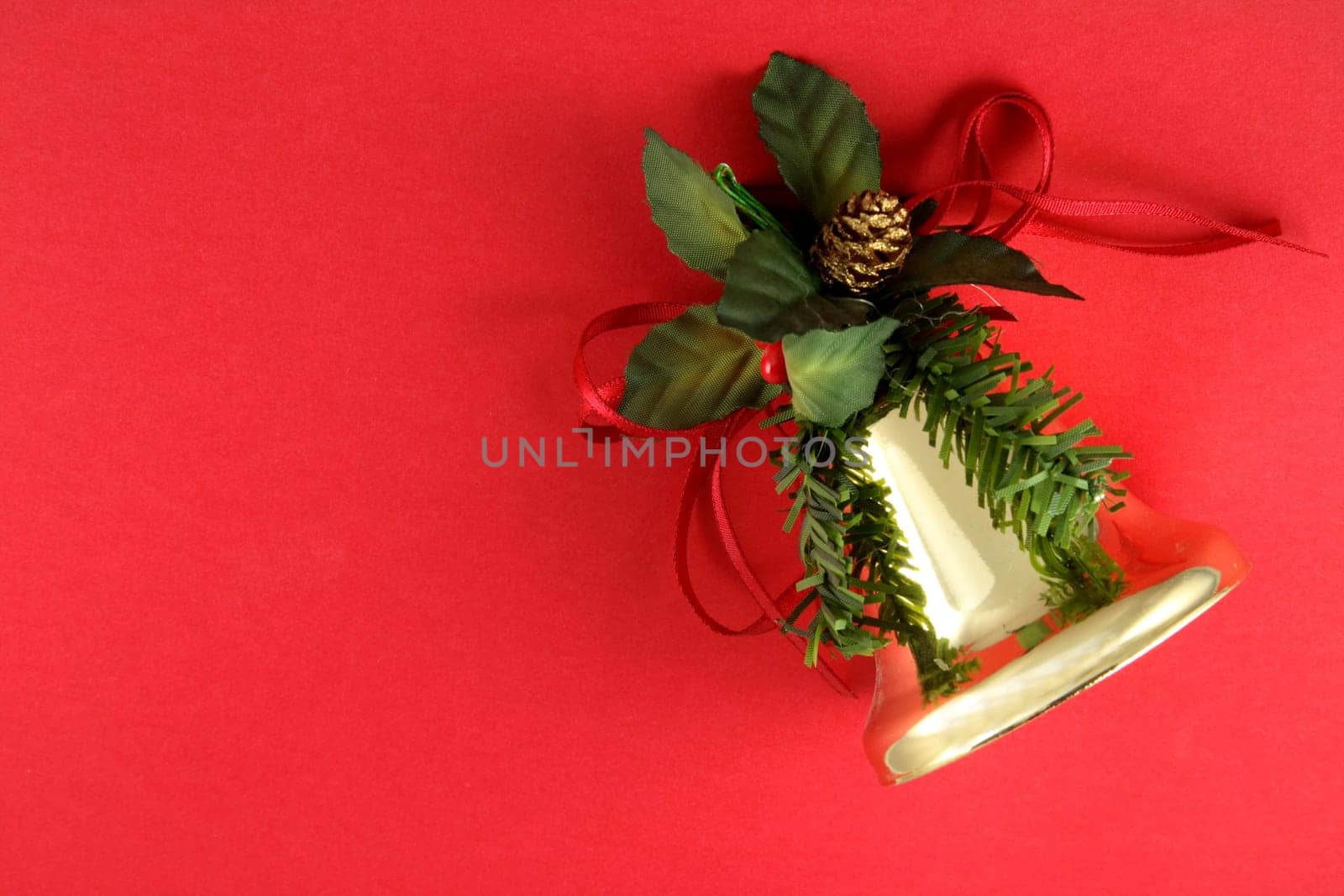 Christmas bell ornament on a red background.
