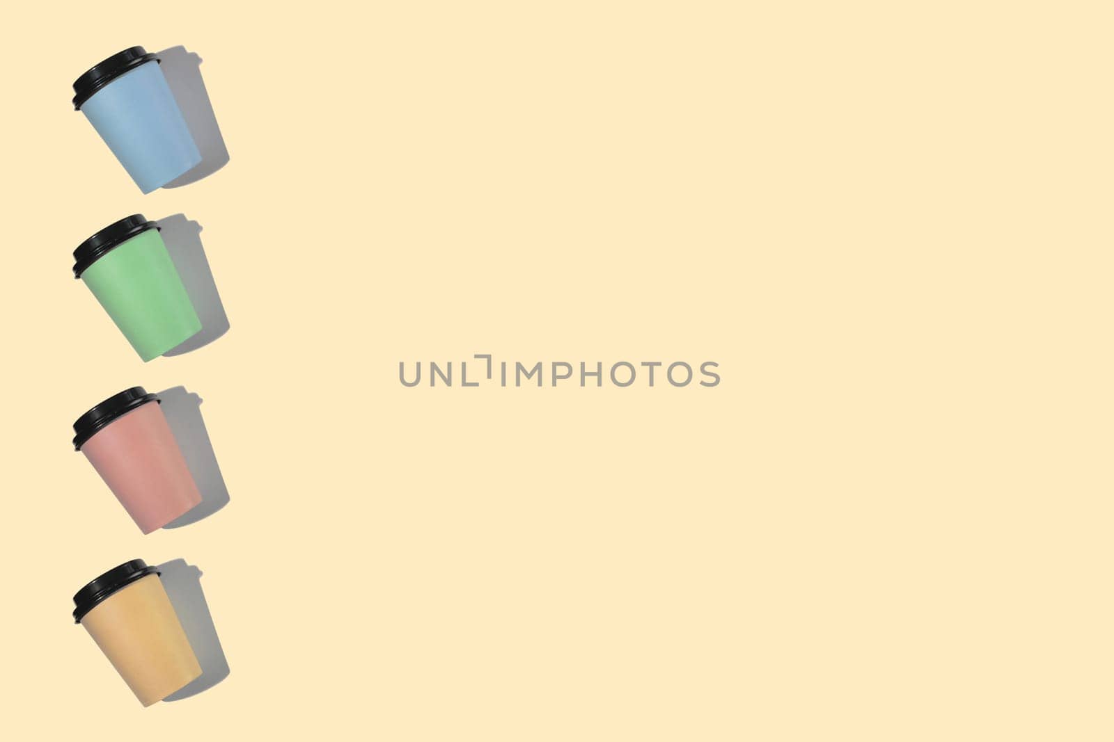 Four multi-colored cardboard coffee cups with a plastic lid on a beige background. Template with copy space. The concept of ecology, recycling, environmental protection.
