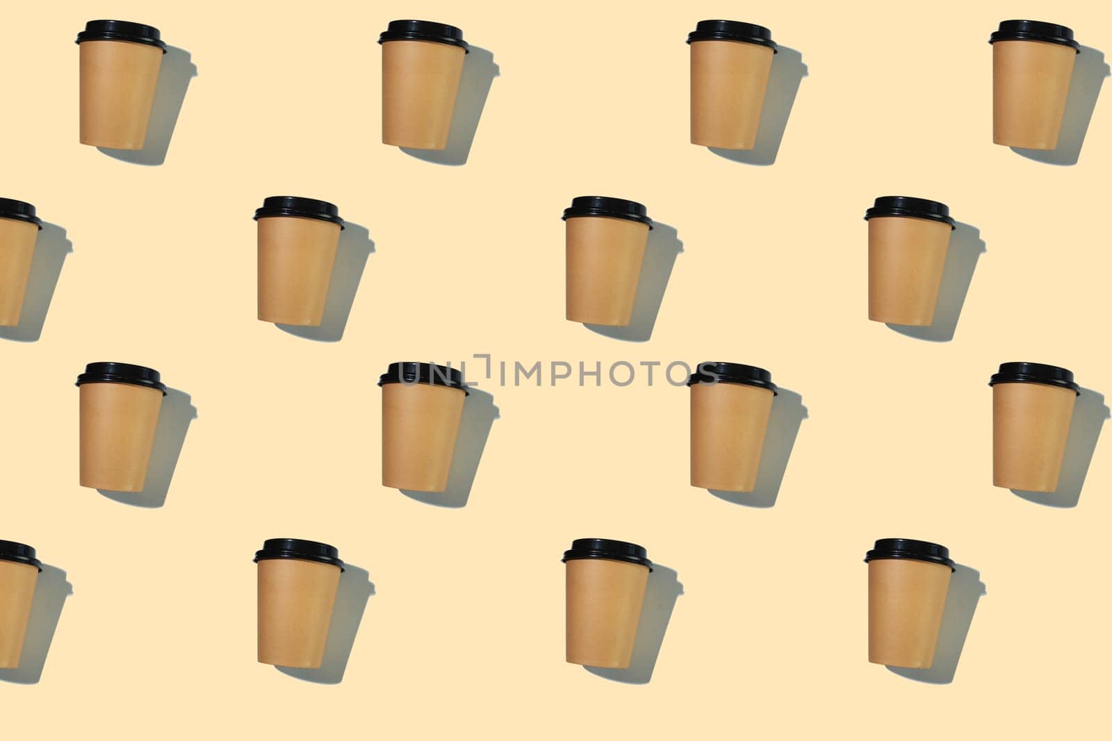 Pattern of cardboard coffee cups with a plastic lid with a hard shadow on a beige background. The concept of ecology, recycling, environmental protection.
