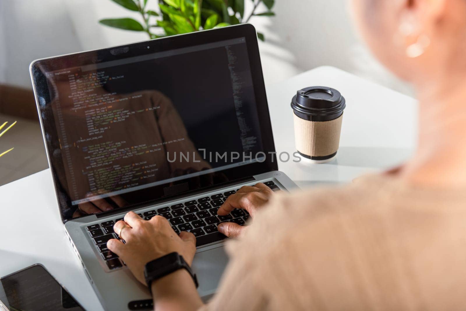 Programmer woman writing program HTML code sitting at workplace in office, IT software developer hands typing data coding programming with laptop computer, IT start up concept, Web application design