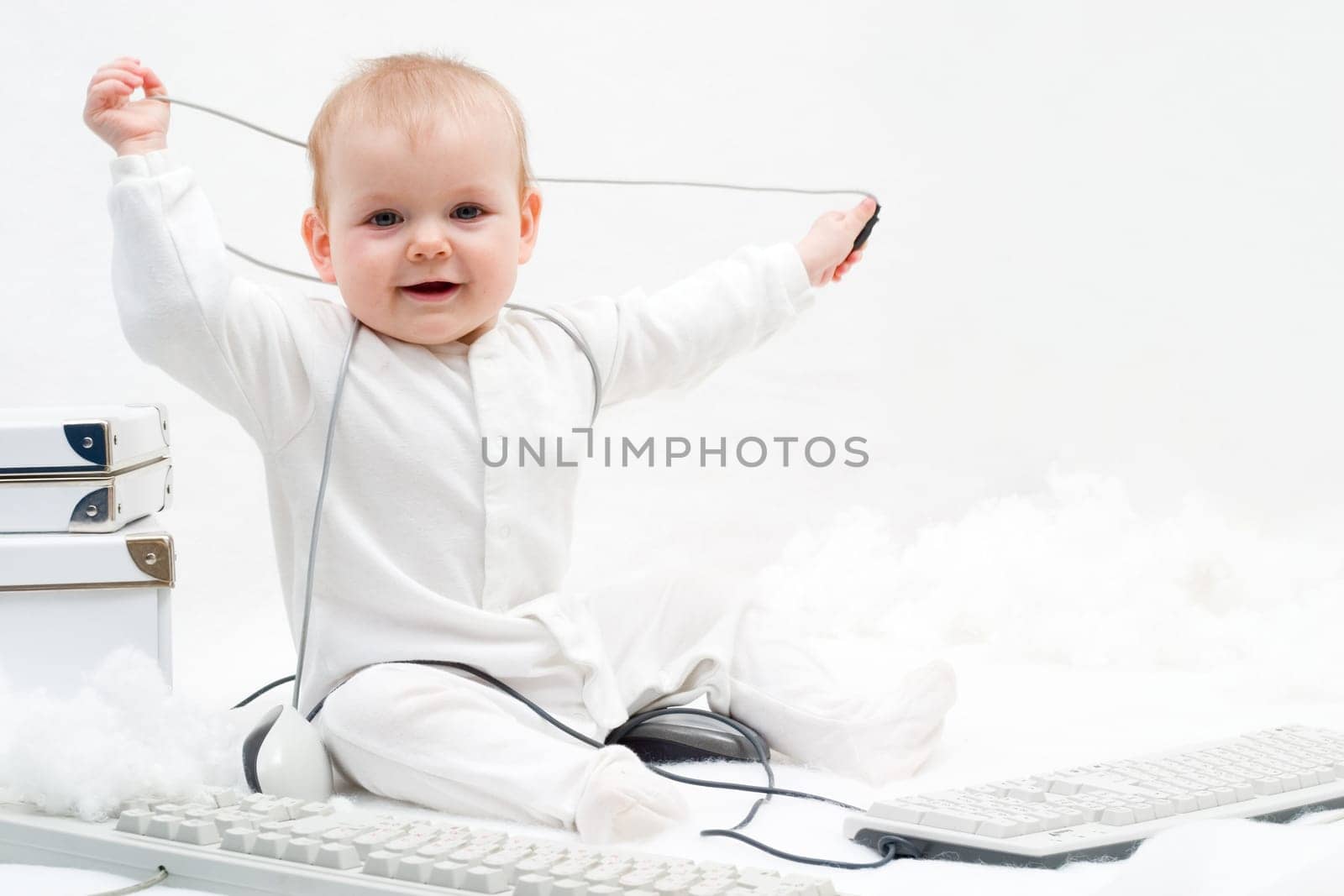 little baby playing with two computer keyboards and mouse