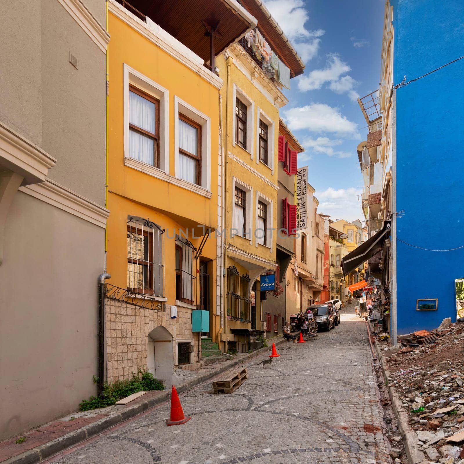 Istanbul, Turkey - August 28, 2022: Traditional colorful old houses in old Balat district, with local pedestrians in a summer day