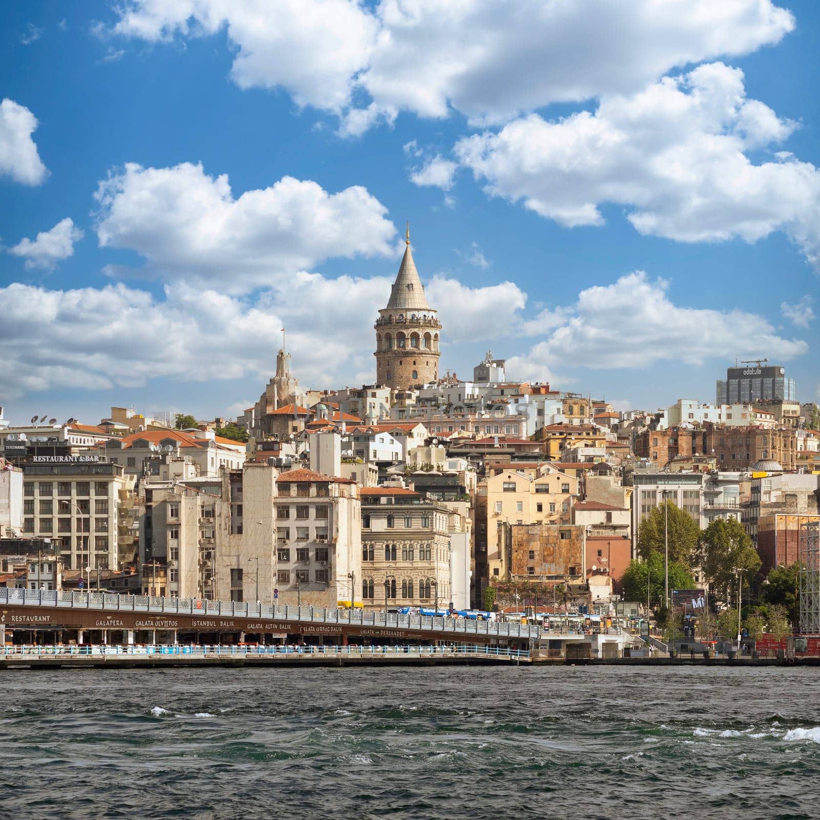 City view of Istanbul skyline, Turkey, from the Bosporous overlooking Galata Bridge with traditional fish restaurants and Galata Tower in the background