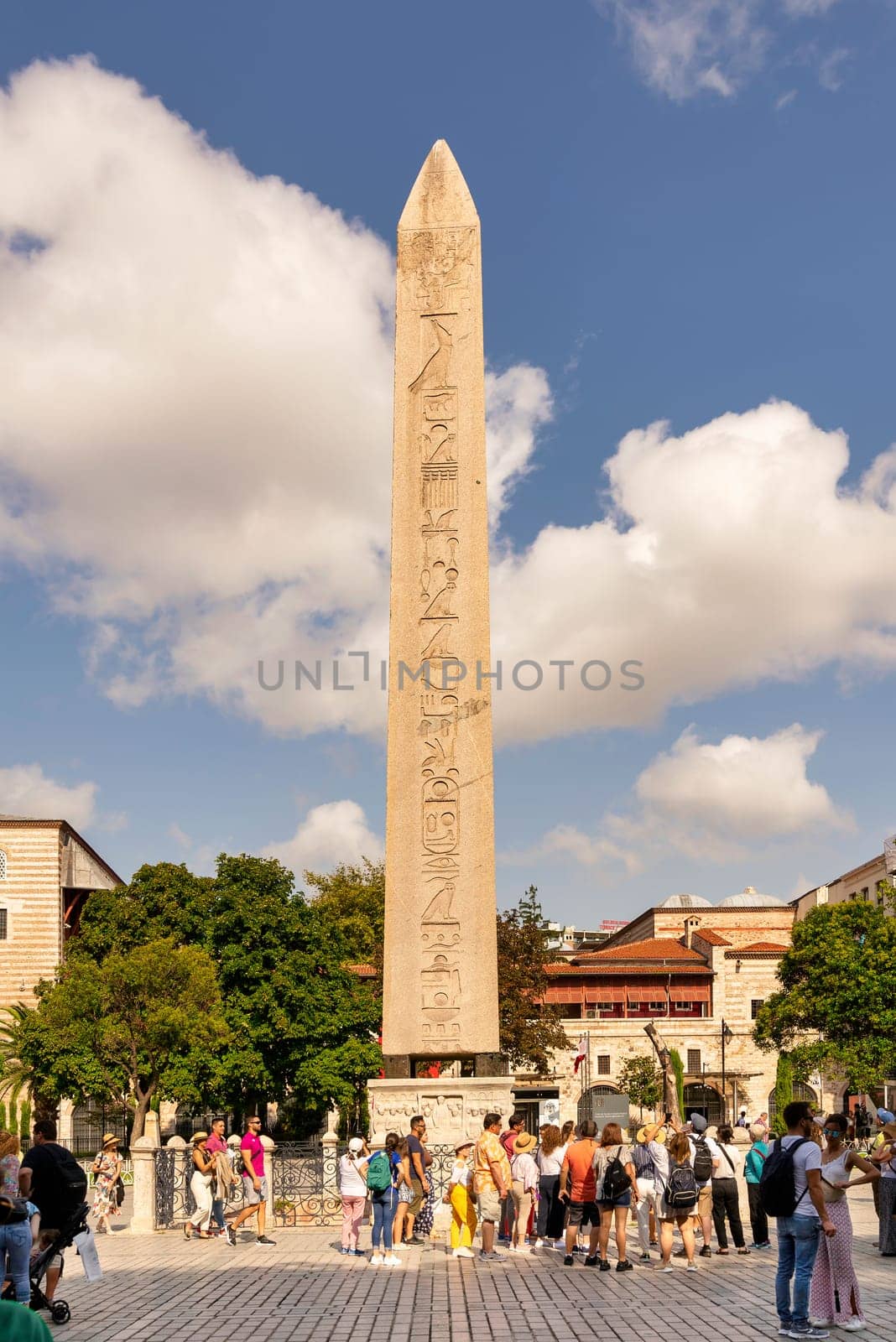 Istanbul, Turkey - August 30 2022: Tourists visiting the Obelisk of Theodosius, ancient Egyptian obelisk of Pharaoh Thutmose III re-erected in the Hippodrome of Constantinople, or Sultanahmet Square
